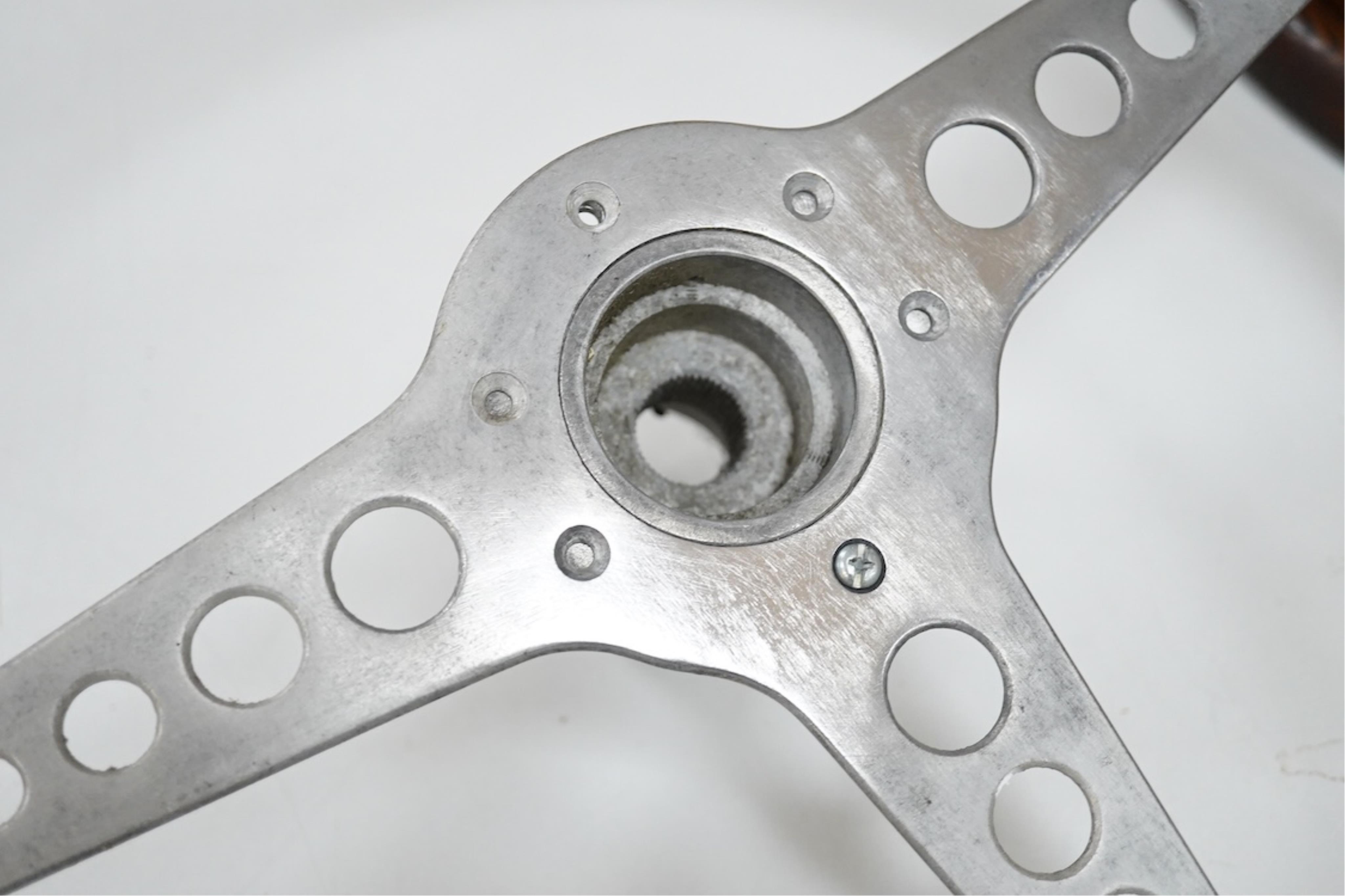 A Jaguar E Type steering wheel in wood and steel, together with the top section of the steering column which bolts to the steering wheel, missing the central Jaguar emblem, 41cm diameter